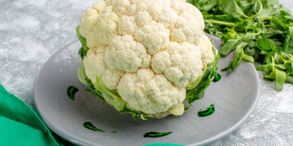 front-view-fresh-cauliflower-with-greens-grey-desk